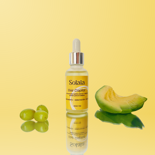 Elixir capilar nutritivo Solaia en frasco cuentagotas, con uvas verdes y una rebanada de aguacate